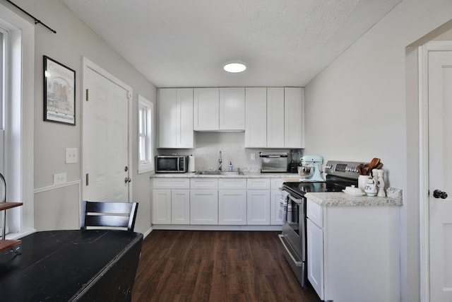 kitchen featuring dark wood-type flooring, sink, a textured ceiling, white cabinetry, and stainless steel appliances