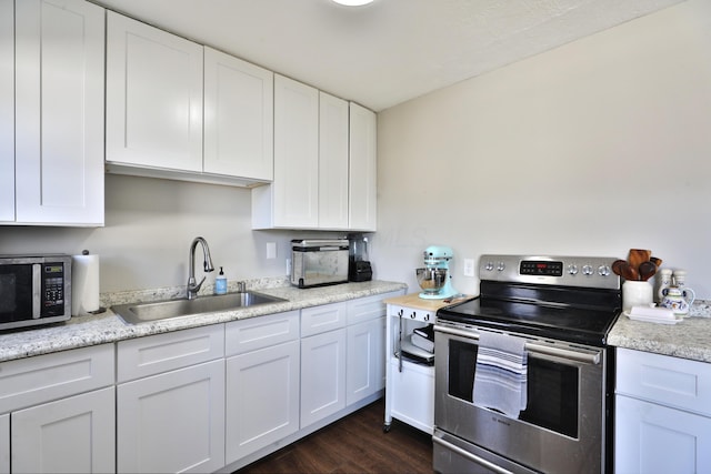 kitchen with white cabinets, stainless steel appliances, dark wood-type flooring, and sink