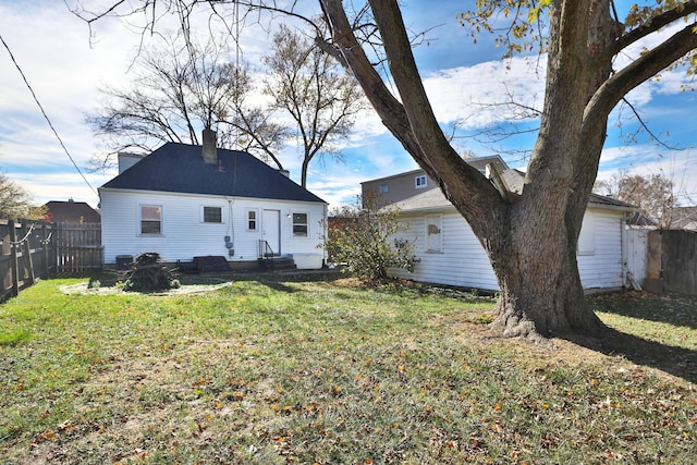 rear view of property featuring a yard