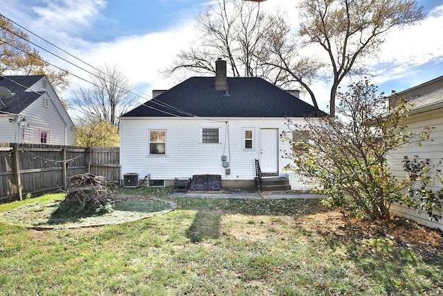 rear view of house with a lawn and central air condition unit