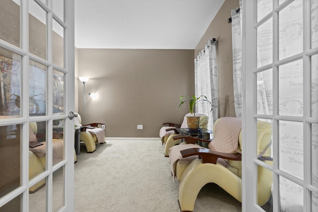 living area featuring carpet flooring, french doors, and vaulted ceiling