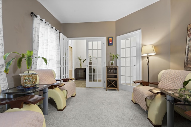 sitting room with french doors and light colored carpet