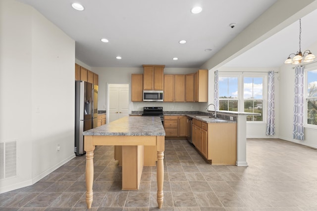 kitchen with a center island, appliances with stainless steel finishes, decorative light fixtures, a kitchen bar, and a chandelier