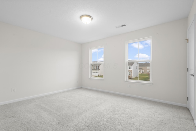 unfurnished room featuring light carpet