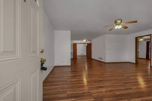 empty room featuring visible vents, baseboards, ceiling fan, and wood finished floors