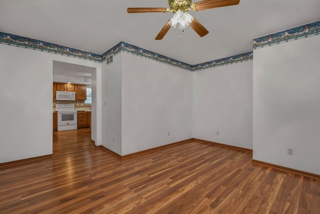 empty room with ceiling fan and dark hardwood / wood-style flooring