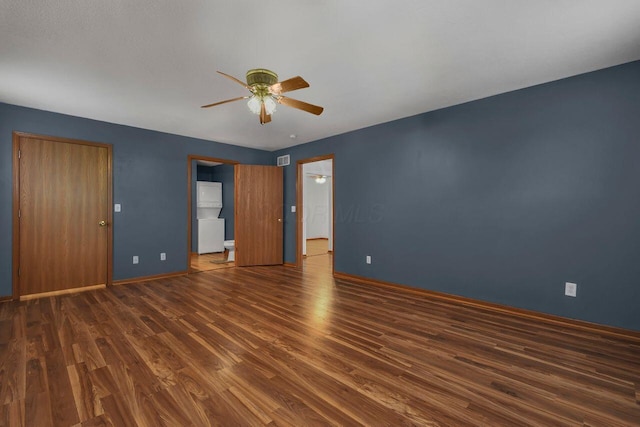 empty room with a ceiling fan, visible vents, wood finished floors, and baseboards