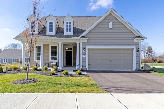 view of front facade featuring covered porch, a garage, and a front yard