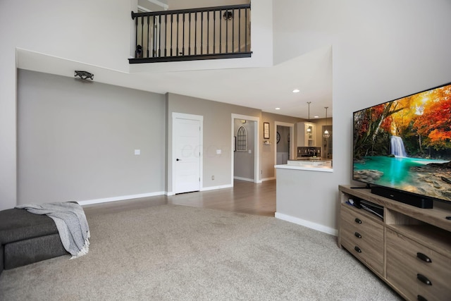 carpeted living room with a high ceiling