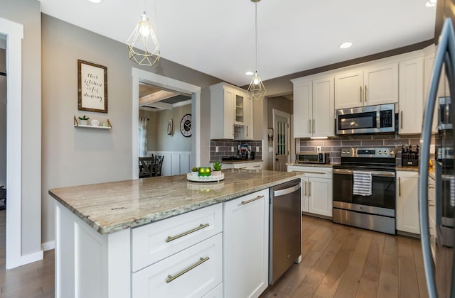 kitchen featuring decorative backsplash, appliances with stainless steel finishes, dark wood-type flooring, decorative light fixtures, and white cabinets