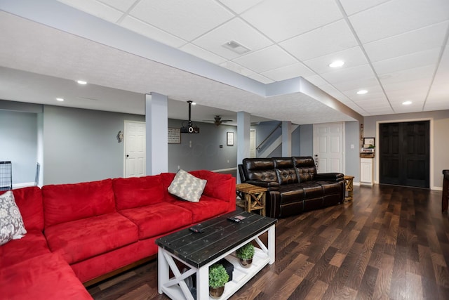 living room featuring a paneled ceiling and dark hardwood / wood-style flooring