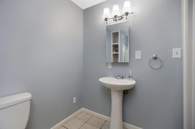 bathroom featuring toilet, tile patterned floors, and sink