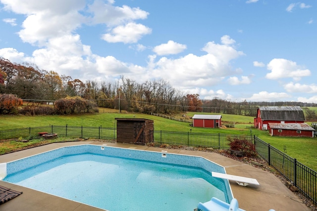 view of pool featuring a storage unit, a diving board, and a yard