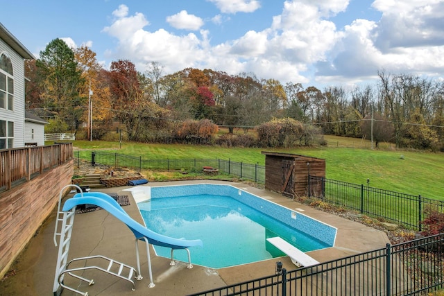 view of swimming pool with a patio area, a diving board, a lawn, and a water slide