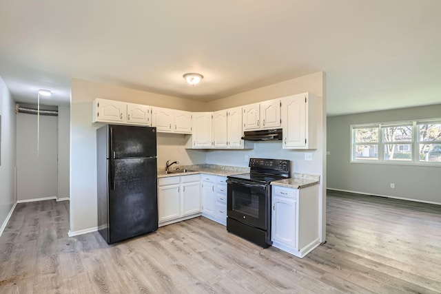 kitchen with sink, white cabinets, black appliances, and light wood-type flooring