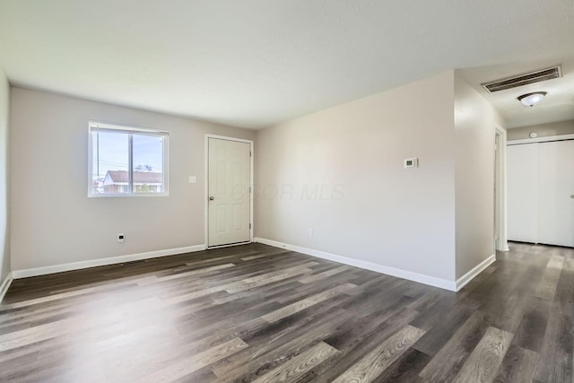 unfurnished room with dark wood-type flooring