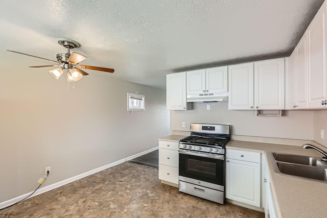 kitchen with a textured ceiling, ceiling fan, sink, white cabinets, and stainless steel gas stove