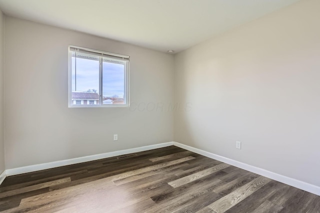 empty room with dark hardwood / wood-style flooring