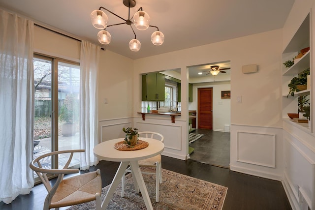 dining area featuring sink, dark wood-type flooring, and a chandelier