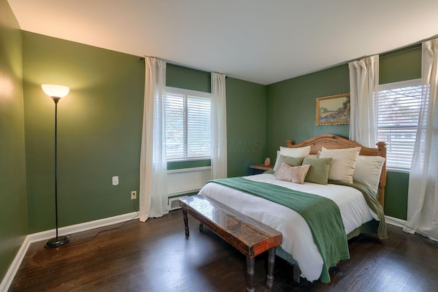 bedroom featuring multiple windows and dark hardwood / wood-style floors