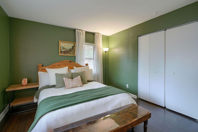 bedroom with dark hardwood / wood-style floors and a closet