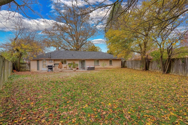 rear view of property featuring cooling unit, a patio area, and a lawn