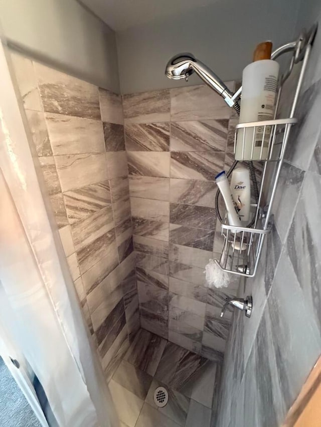 bathroom featuring tile patterned flooring and tiled shower