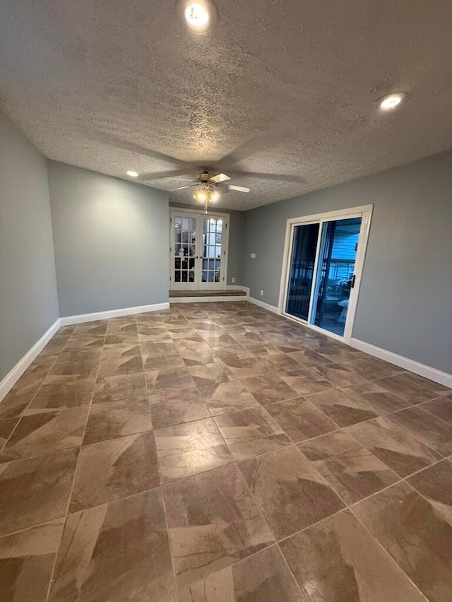 unfurnished room featuring ceiling fan, french doors, and a textured ceiling