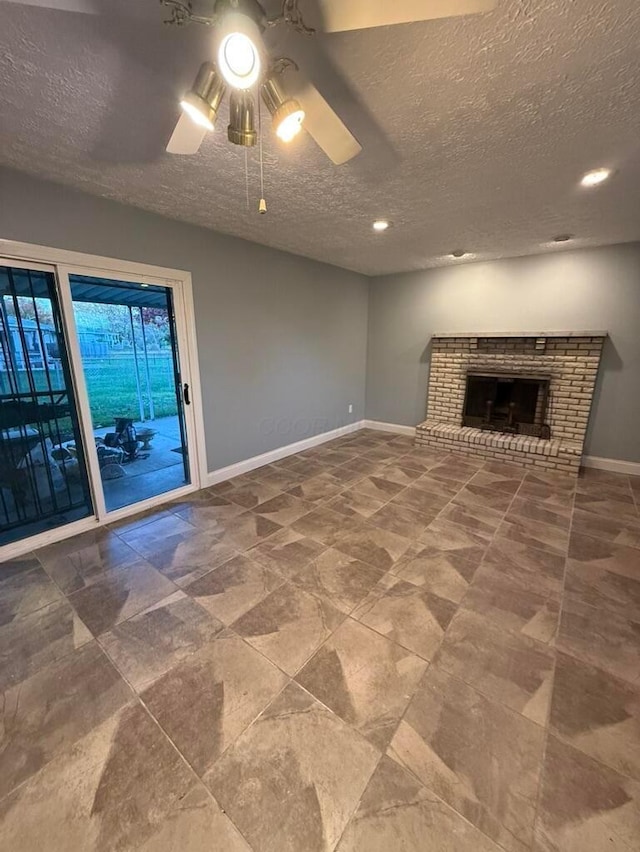 unfurnished living room with a textured ceiling, ceiling fan, and a fireplace