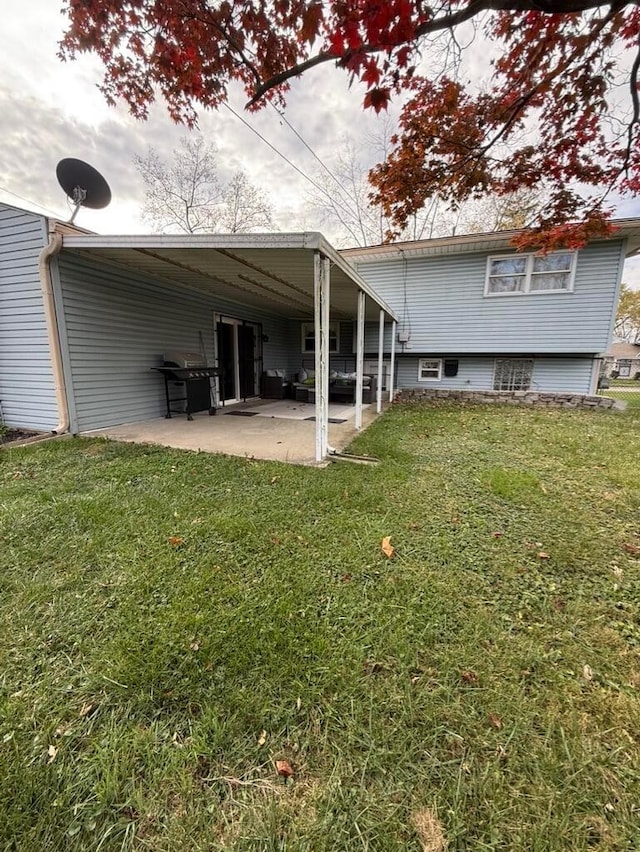 back of property with a carport and a lawn