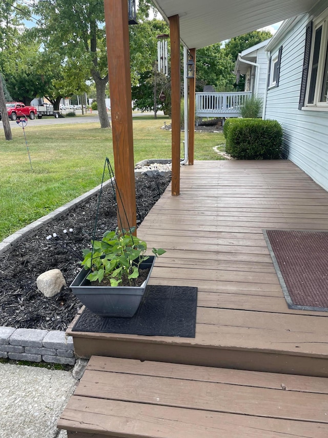 wooden deck with a lawn and a porch