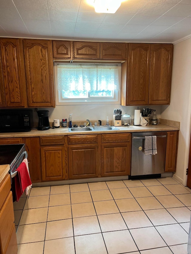 kitchen with sink, light tile patterned flooring, and appliances with stainless steel finishes