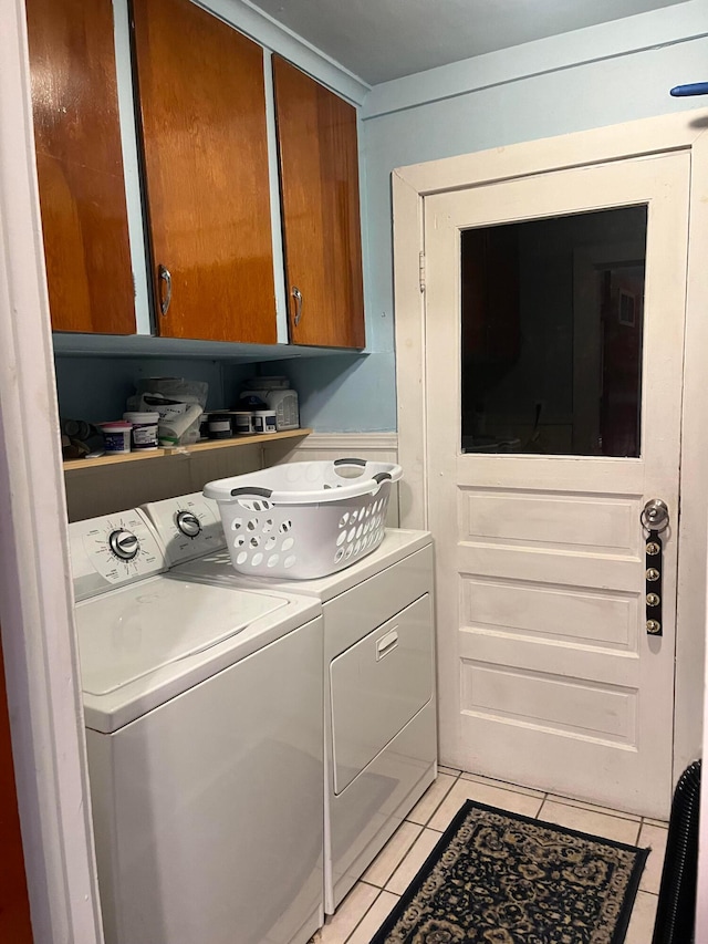 washroom with cabinets, separate washer and dryer, and light tile patterned floors