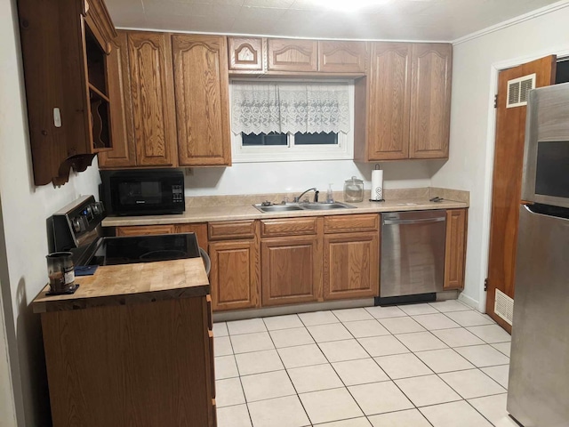 kitchen featuring crown molding, appliances with stainless steel finishes, sink, and light tile patterned floors