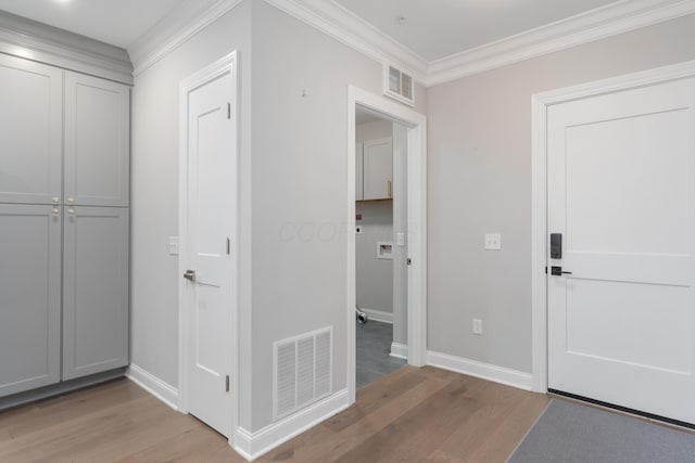 foyer entrance featuring ornamental molding and hardwood / wood-style flooring