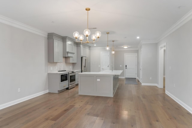 kitchen with pendant lighting, gray cabinetry, a center island with sink, light hardwood / wood-style flooring, and stainless steel appliances