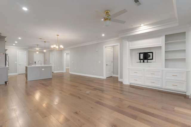 unfurnished living room featuring ceiling fan with notable chandelier, light wood-type flooring, crown molding, and sink