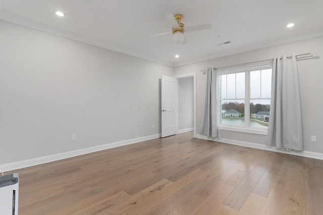 empty room with ceiling fan, light wood-type flooring, and ornamental molding