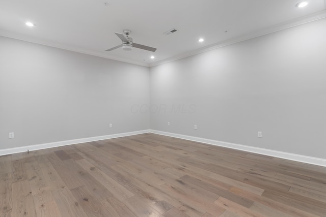 spare room featuring ceiling fan, light wood-type flooring, and crown molding