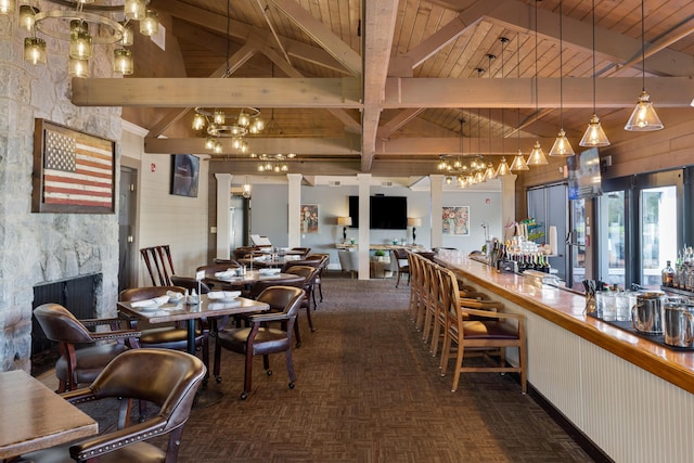 dining area featuring beam ceiling, wooden ceiling, a fireplace, and high vaulted ceiling