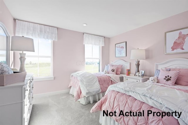 bedroom featuring light carpet and multiple windows