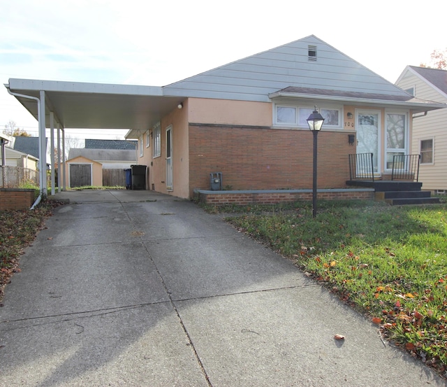 view of front of home with an outbuilding and a carport