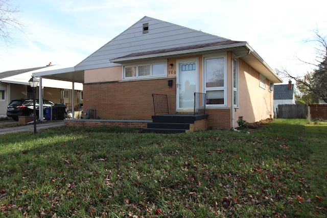 view of front of house with a front yard and a carport