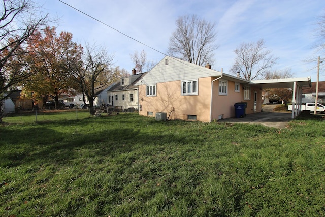 view of property exterior with central AC, a yard, and a carport