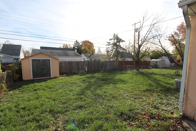 view of yard featuring central AC unit and a shed