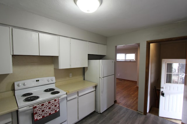 kitchen with dark hardwood / wood-style flooring, white appliances, and white cabinetry