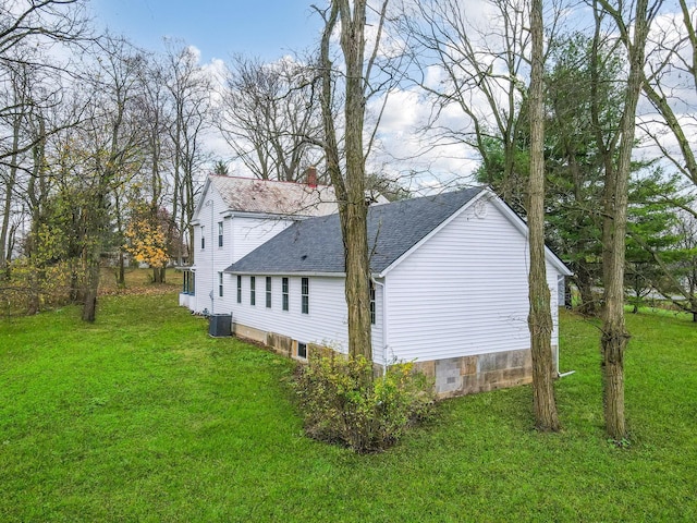 view of side of home with a yard and central air condition unit