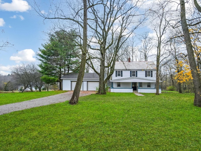 view of front of house with covered porch, a front yard, and a garage