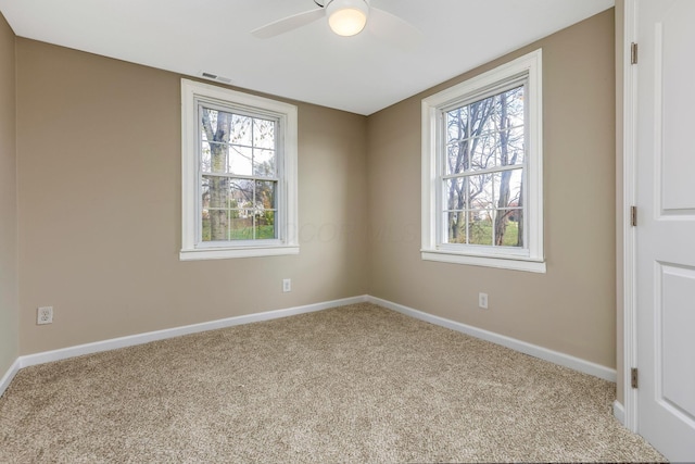 carpeted empty room featuring plenty of natural light and ceiling fan