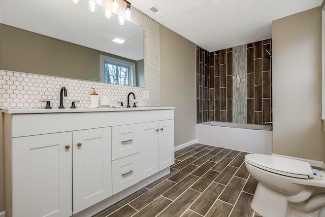 full bathroom with backsplash, vanity, shower / bathtub combination, and toilet